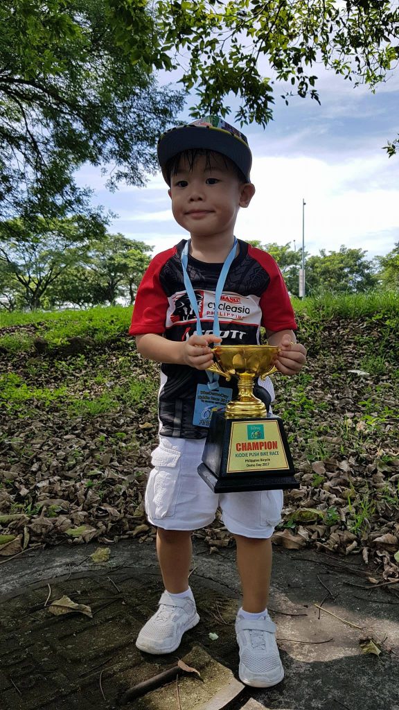 Luis with his trophy for the kiddie push bike race he won