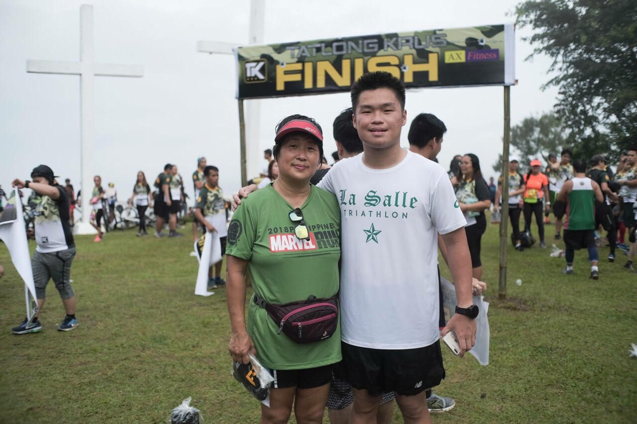 Vince Ang and his proud mother pose for a photo with his son after finishing a trail run last month