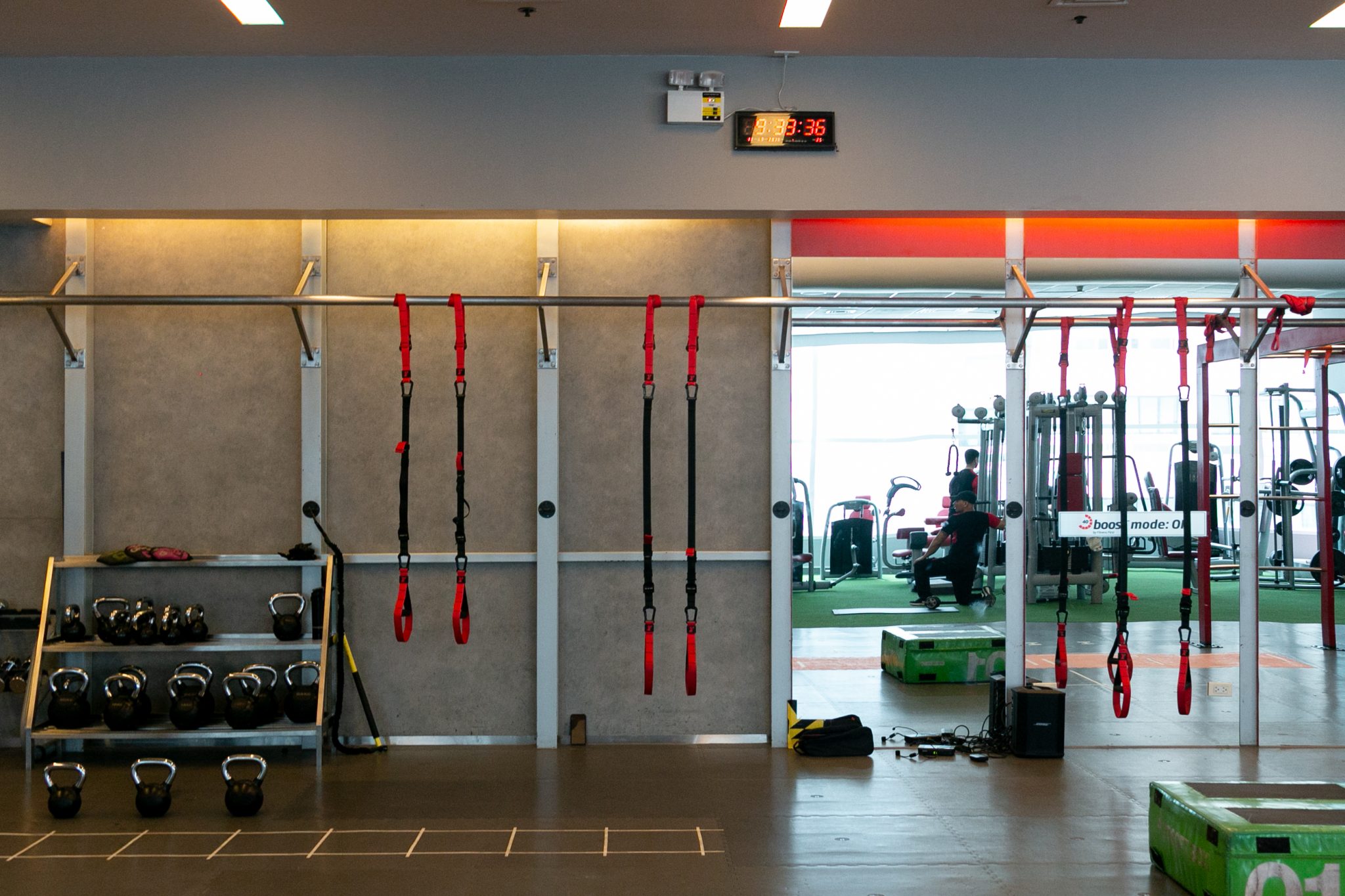 The Spartan group workout setup includes kettlebells, suspended row straps, and a plyo box