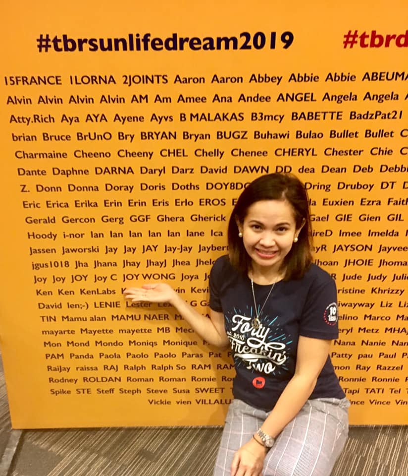The author feeling happy to see her name on the wall during the send-off party and race orientation of their first marathon