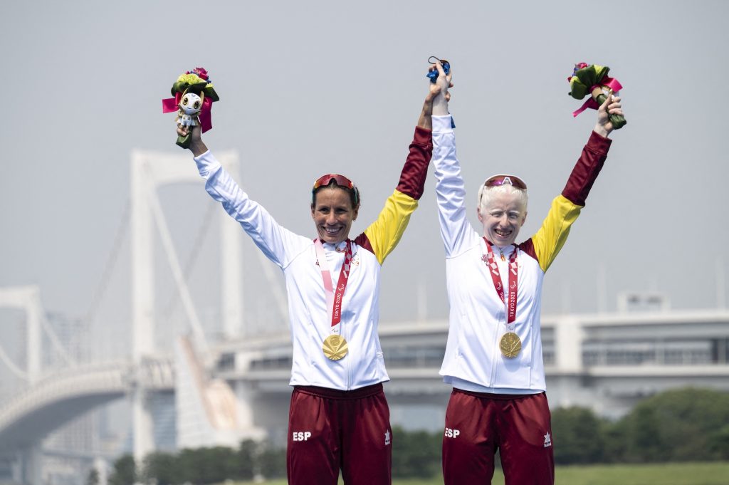 Susana Rodriguez and her guide Sara Loehr pose with their gold medals after competing in the women's triathlon category PTVI