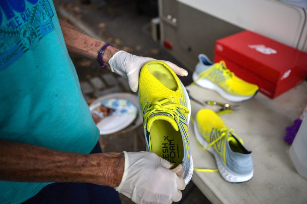 A technician checks the shoes of Harita Davies of New Zealand during the 