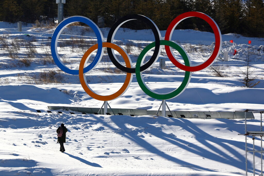 FILE PHOTO: A person walks past the Olympic rings in the Zhangjiakou competition zone ahead of the Beijing 2022 Winter Olympics
