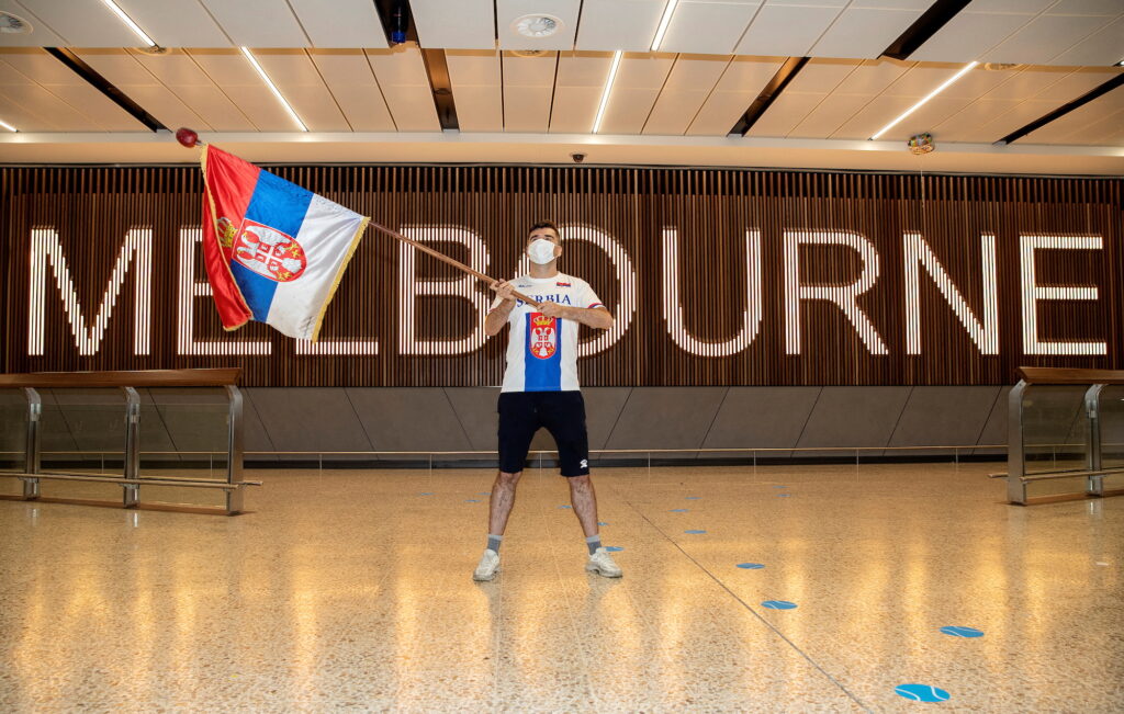A fan of Serbian tennis player Novak Djokovic is seen waving a Serbian flag while awaiting the arrival of Djokovic at Melbourne International Airport in Melbourne, Australia