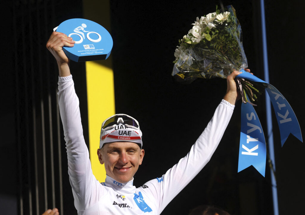 Tadej Pogacar wearing the white jersey celebrates on the podium after Stage 12