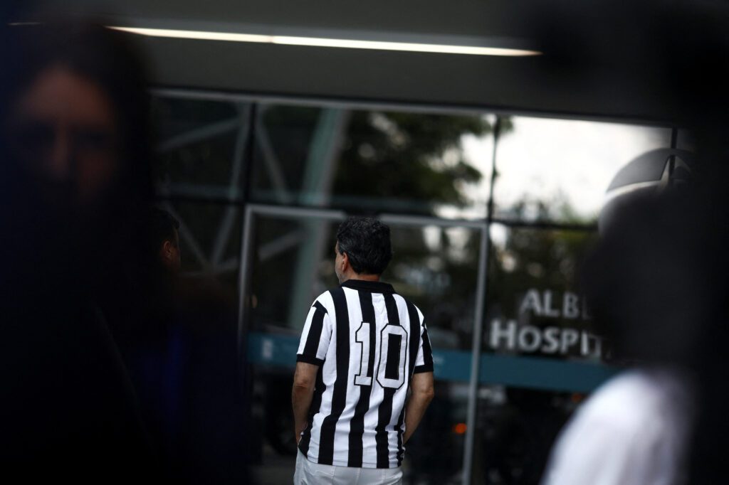 A man wearing the number 10 jersey of the Santos team mourns the death of Brazilian soccer legend Pele outside the Albert Einstein Hospital where Pele was hospitalized before his death