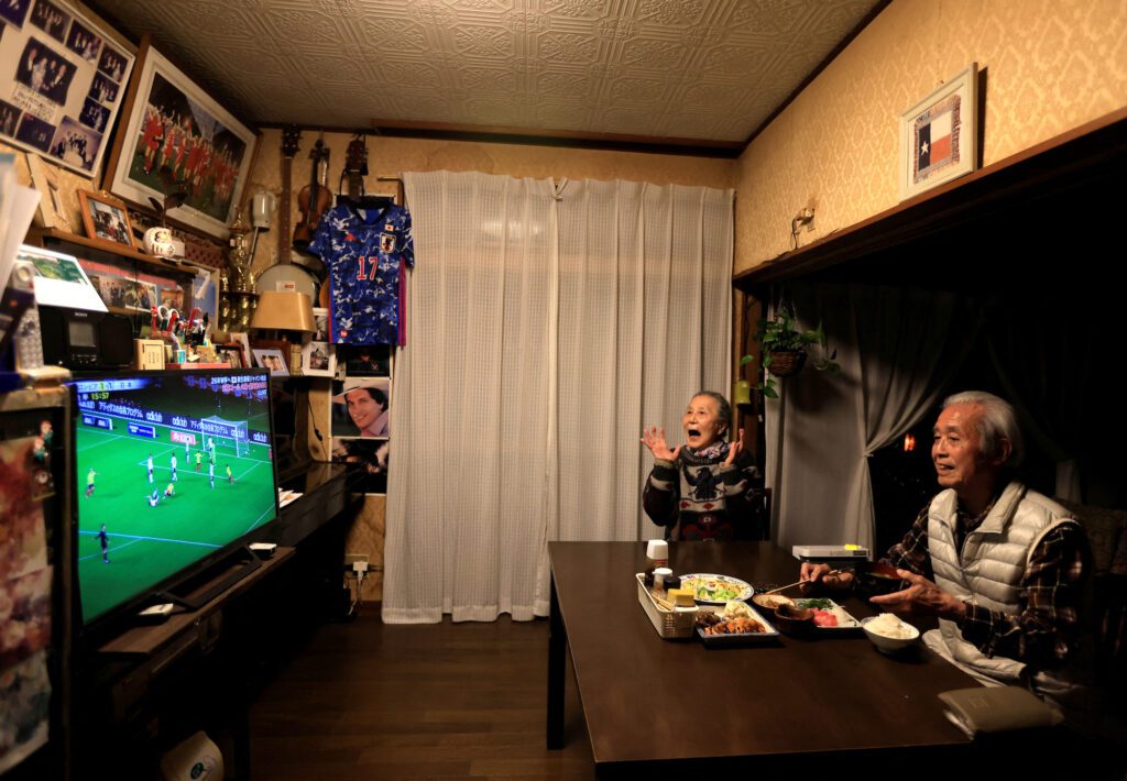 Mutsuhiko Nomura, 83, and his wife Junko Nomura, 80, watch the Japanese national team’s soccer match against Colombia, at their home in Tokyo, Japan