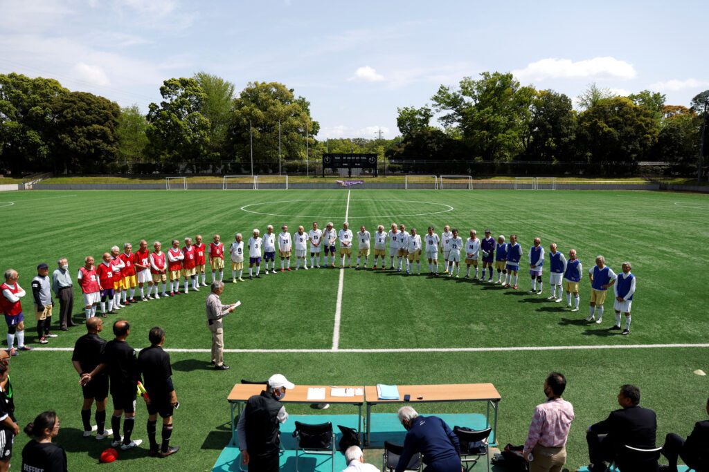 Players from Red Star, White Bear, and Blue Hawaii attend the opening ceremony of the SFL (Soccer For Life) 80 League in Tokyo, Japan