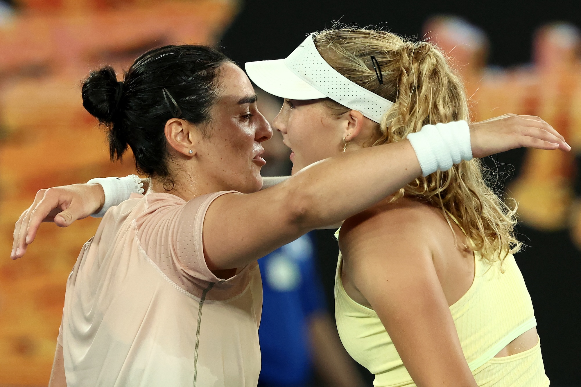 Russia's Mirra Andreeva (R) hugs Tunisia's Ons Jabeur after their women's singles match on day four of the Australian Open tennis tournament in Melbourne on January 17, 2024. (Photo by David GRAY / AFP)